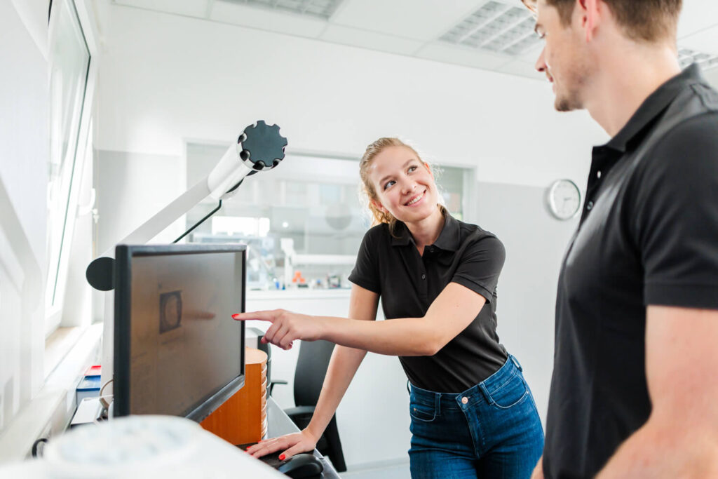 Mitarbeiter besprechen Mitarbeiterbindung und soziale Verantwortung bei einem Betriebsübergang unter 10 Mitarbeitern eines Dentallabors